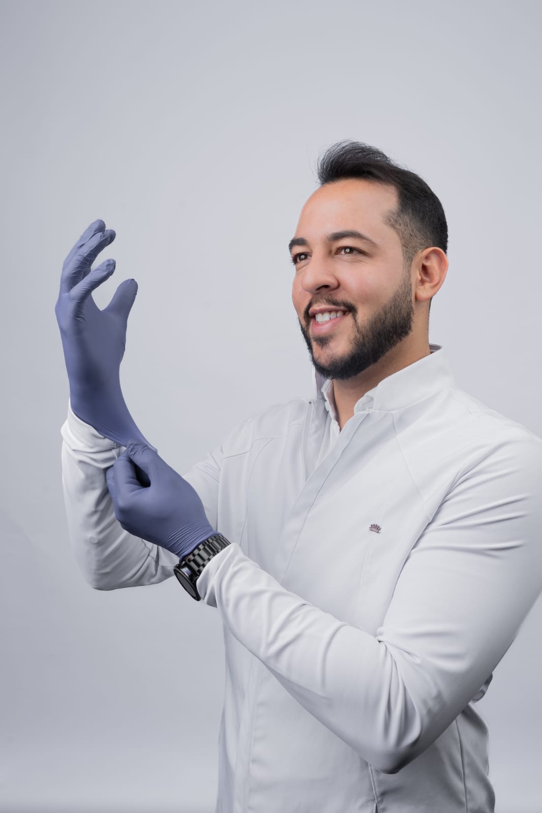 Dr. Rafael Assis calçando luvas antes de um procedimento na Odontec